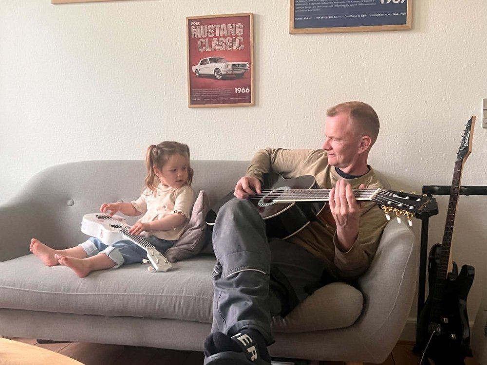 Far og datter spiller guitar