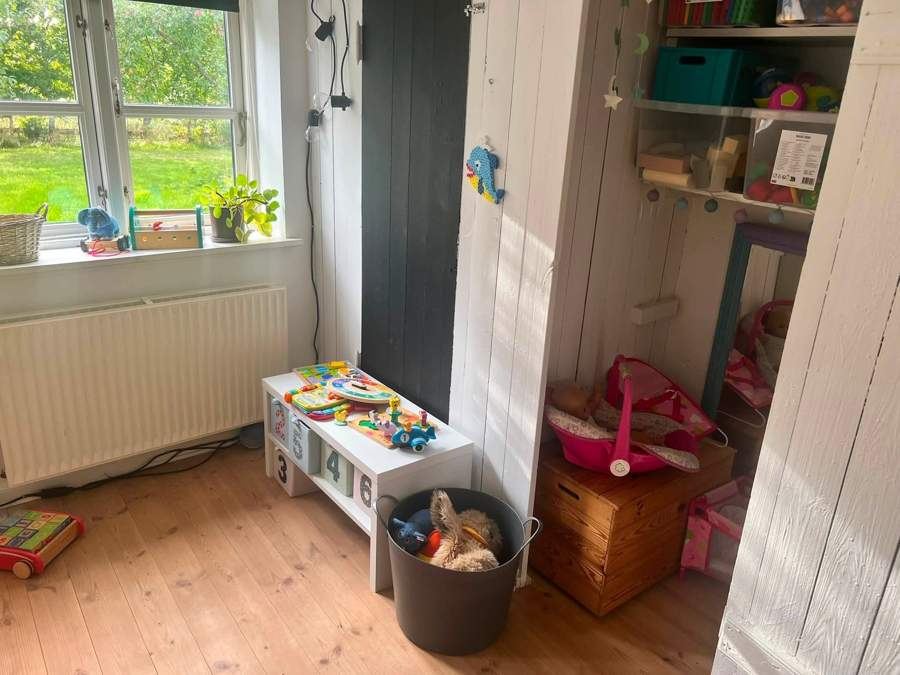 Hyggelig vindueskrog med legetøj og reol
